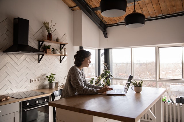 Young woman browsing Gumtree on laptop in kitchen. Photo by Ekaterina Bolovtsova from Pexels